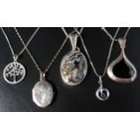 FIVE SILVER AND SILVER MOUNTED PENDANTS ON CHAINS including a diamond and gem set tree design