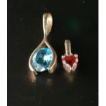 TWO GEM SET NINE CARAT GOLD PENDANTS comprising an oval cut blue topaz set pendant, the topaz