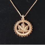 TEN CARAT GOLD PENDANT AND CHAIN the pendant with central leaf within pierced circular surround,