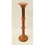 LIGHT OAK TORCHERE STAND raised on a circular base with a grooved column, 100cm high