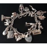 SILVER CHARM BRACELET the charms including a hedgehog, a champagne bottle and bucket, a pair of