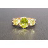 GRADUATED PERIDOT THREE STONE RING the central oval cut peridot approximately 1.2cts flanked by