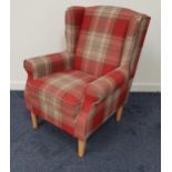 MODERN ARMCHAIR covered in a red plaid material with scroll arms above a padded seat, standing on