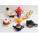 SEVEN NOVELTY TEAPOTS comprising a Wade Tetley teapot, a Pillar Box, a camera, a cup cake, Aladdin's