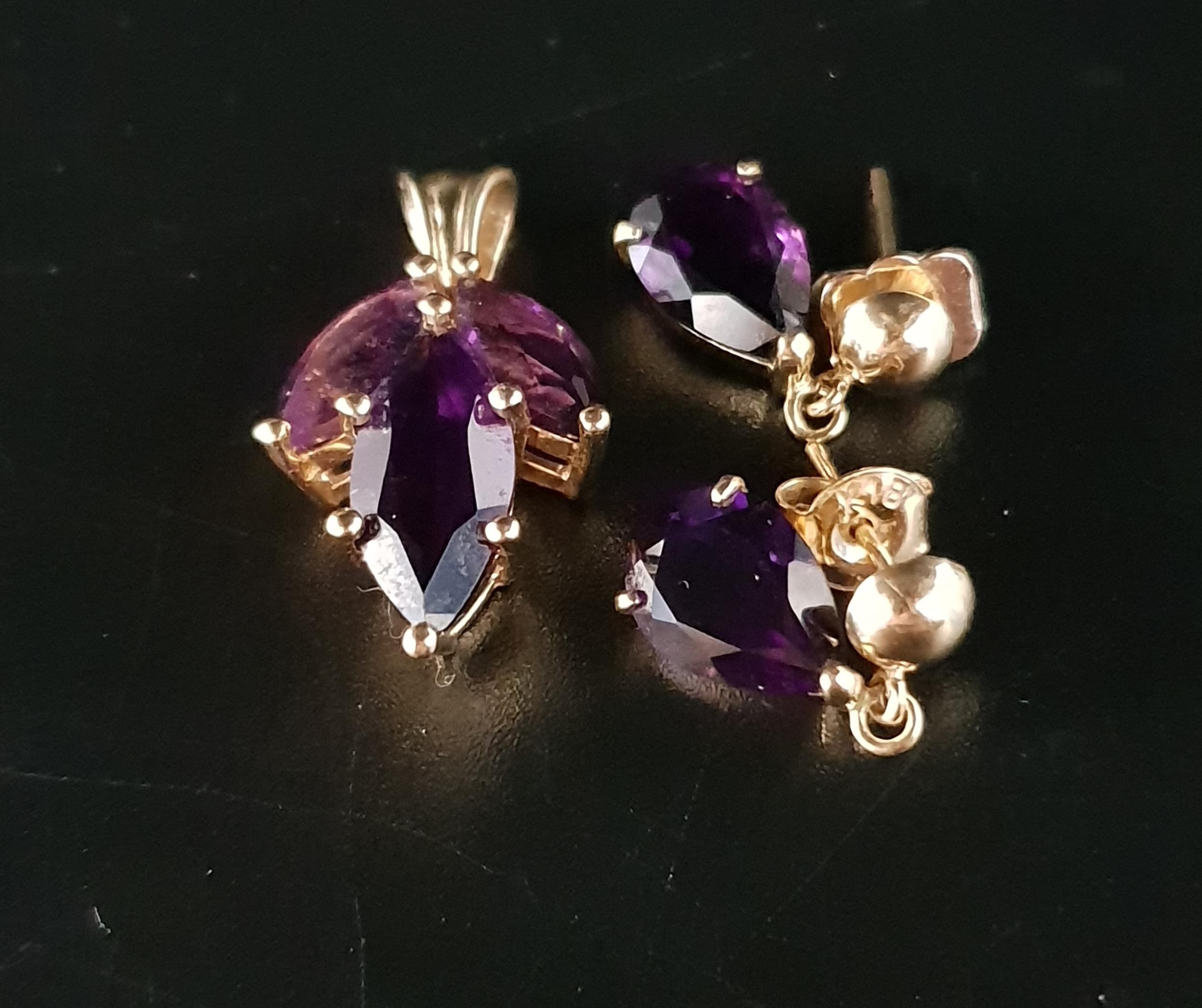 AMETHYST SUITE OF JEWELLERY comprising a pendant set with three marquise cut amethysts and a pair of