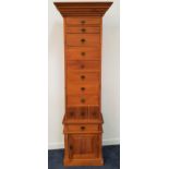 LARGE LIGHT TEAK CHEST with a moulded stepped top above eight graduated drawers and three narrow