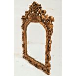 ARCHED WALL MIRROR in a carved and pierced giltwood frame with a plain plate, 59cm high