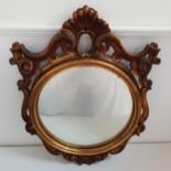 CONVEX WALL MIRROR with a circular plate in a carved and pierced frame, 78cm high