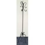 DECORATIVE WROUGHT IRON COAT STAND raised on four shaped supports, the central column with three