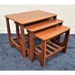 RETRO TEAK NEST OF THREE TABLES with oblong tops, standing on shaped supports, the smallest table