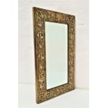 RECTANGULAR WALL MIRROR with a bevelled plate in a brass embossed frame, 49cm high