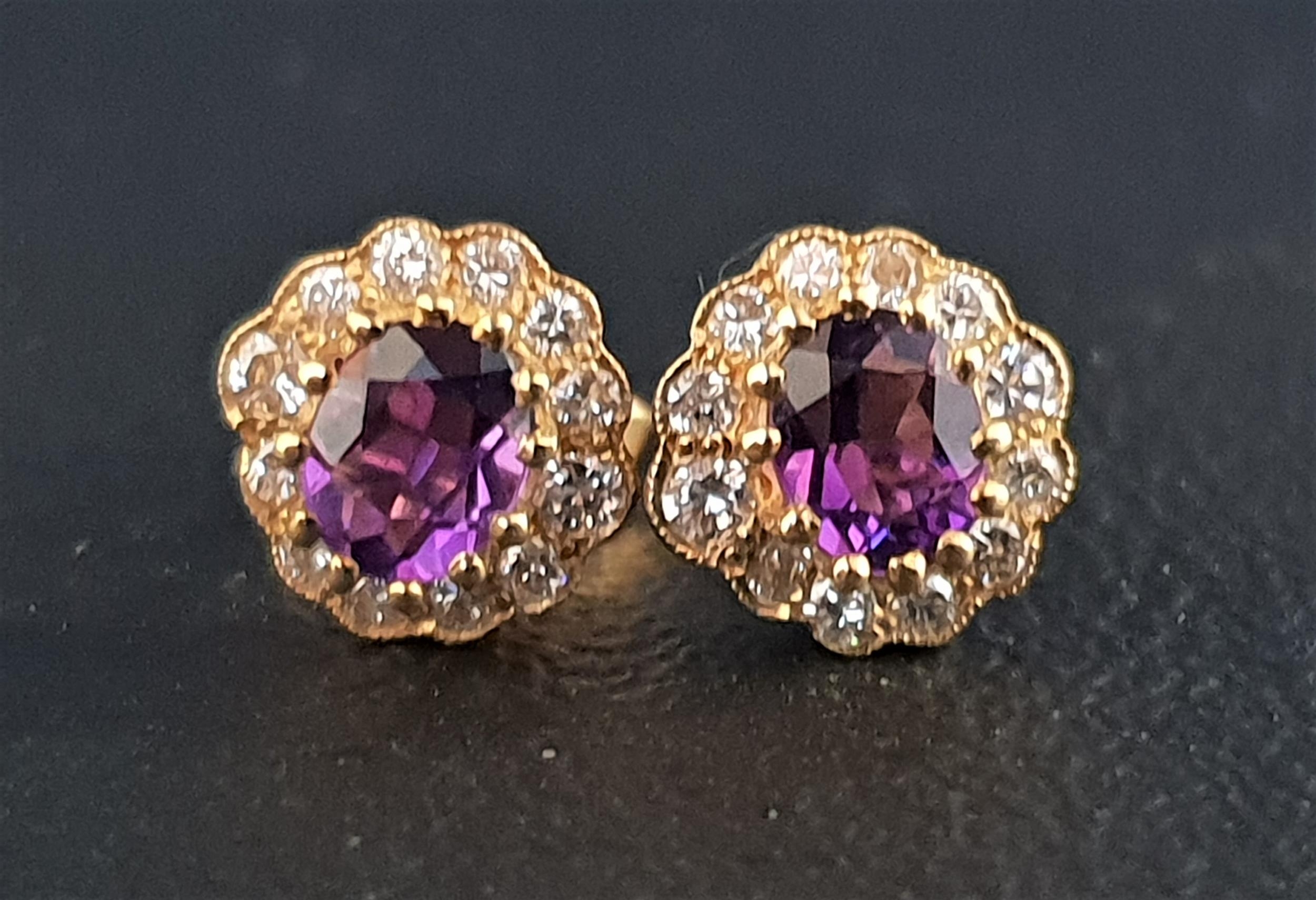 PAIR OF AMETHYST AND DIAMOND CLUSTER EARRINGS each stud earring with central oval cut amethyst of