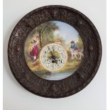 DECORATIVE WALL CLOCK with a central painted panel depicting figures by a stream in a metal surround