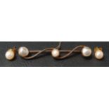 EDWARDIAN PEARL SET BAR BROOCH on scroll design unmarked gold bar with a mabe pearl to each end