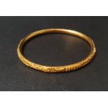 TWENTY-TWO CARAT GOLD BANGLE with relief detail, approximately 10 grams