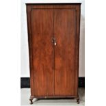 WALNUT WARDROBE with a pair of panelled doors opening to reveal hanging space, four shelves and a