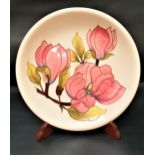 MOORCROFT MAGNOLIA PATTERN PLATE with a cream ground and impressed mark with a painted WM, 26cm