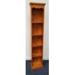 WAXED PINE BOOKCASE of narrow proportions with a moulded top and shaped frieze above five shelves,