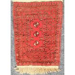 AFGHAN PRAYER MAT with a red ground and three central medallions, encased by a border, fringed, 88cm