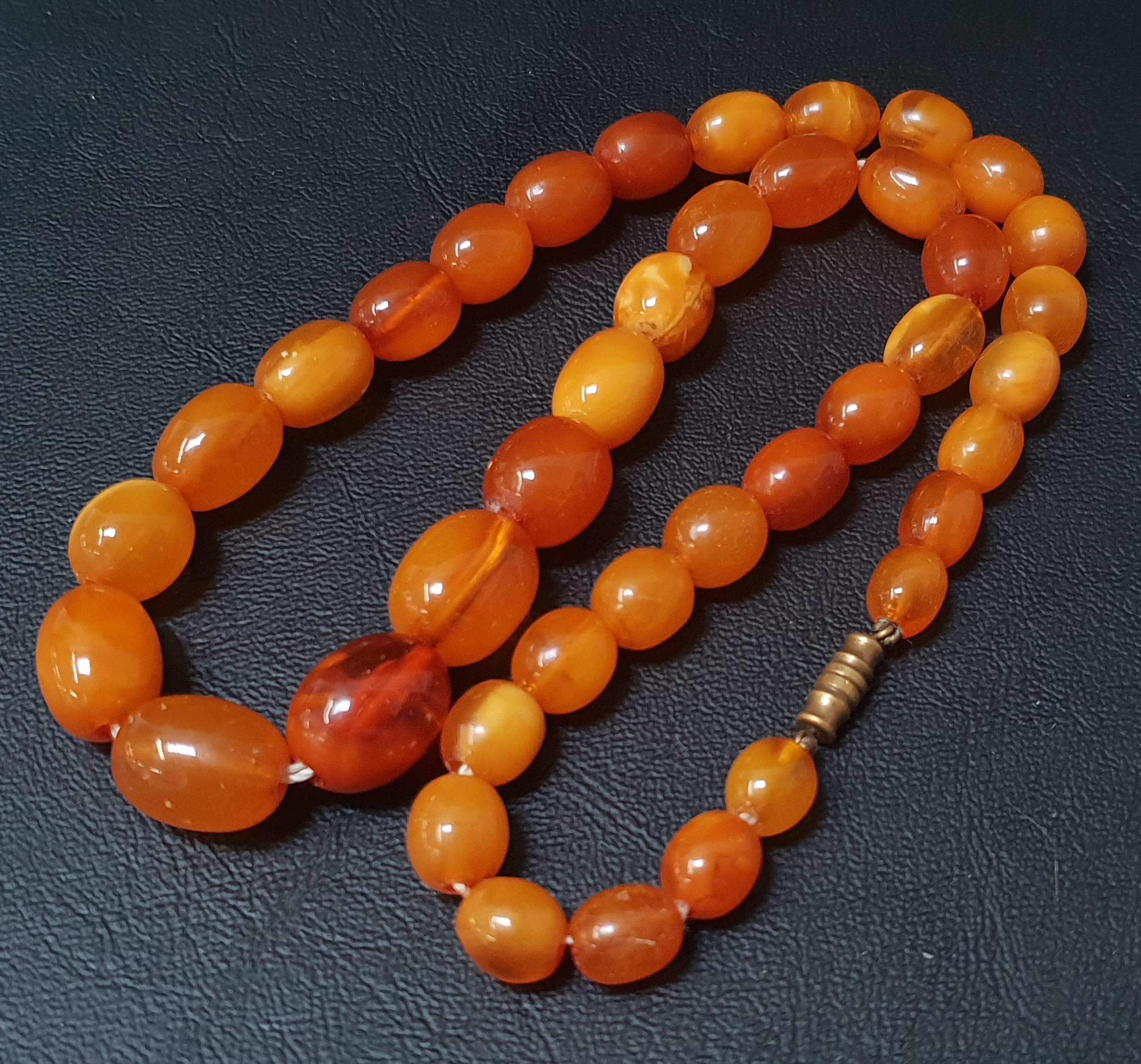 GRADUATED AMBER BEAD NECKLACE the largest bead approximately 1.5cm long, total weight