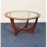 G PLAN TEAK ASTRO OCCASIONAL TABLE with a circular glass inset top, standing on shaped supports,