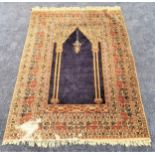 BOKHARA SILK AND WOOL PRAYER RUG with a central navy blue ground with twin gold pillars, encased