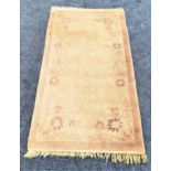 CHINESE STYLE WASH RUG with a pale brown and mauve ground with floral motifs, fringed, 189cm x 96cm