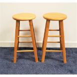 PAIR OF TEAK STOOLS with circular seats and shaped supports, 60.5cm high