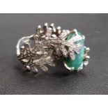 UNUSUAL EMERALD AND DIAMOND DRESS RING the central oval cut emerald within a diamond set fern effect