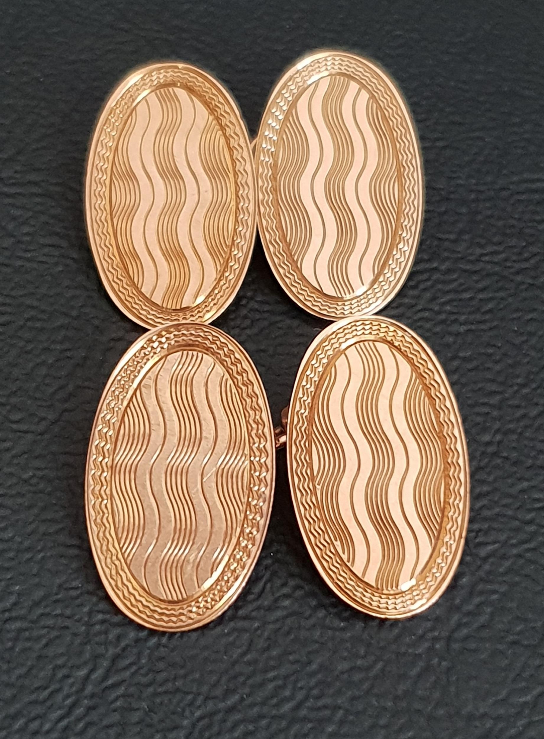 PAIR OF NINE CARAT GOLD CUFFLINKS with oval engine turned disks with chain links, approximately 6.