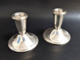 PAIR OF WEIGHTED NEWPORT STERLING SILVER DWARF CANDLESTICKS marked to bases 'Ce'ent filled