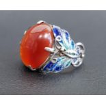UNUSUAL AGATE AND ENAMEL DECORATED RING the central oval cabochon agate flanked by enamel