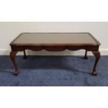 MAHOGANY OCCASIONAL TABLE with an inset glass top, standing on cabriole supports with claw and