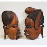 AFRICAN CARVED TEAK WALL PLAQUE of a male and female head in profile, 47cm and 45cm high (2)