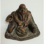 VINTAGE CAST IRON INKWELL depicting a large man seated with his hat beside him, eating a roast