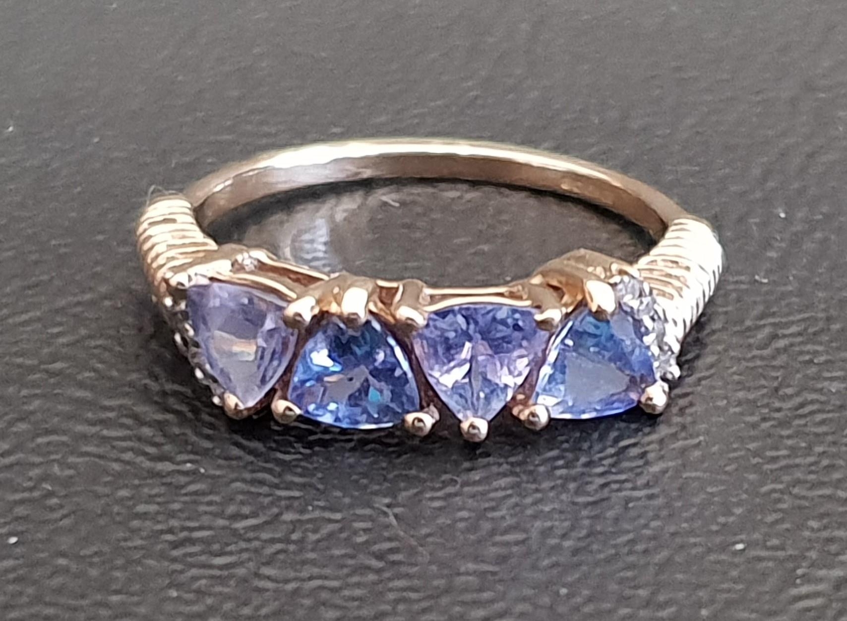 TANZANITE FOUR STONE RING the four trillion cut tanzanites on nine carat gold shank with ribbed