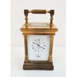 SMALL GILT BRASS FRENCH CARRIAGE CLOCK with five bevelled glass panels, the enamel dial with Roman