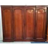 VICTORIAN MAHOGANY INVERTED BREAKFRONT WARDROBE with four arched panelled doors opening to reveal