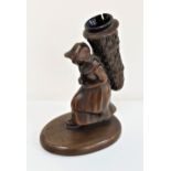 BRONZE DESK ORNAMENT PEN HOLDER in the form of a woman carrying a woven basket on her back, on an