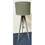 TRIPOD STANDARD LAMP on shaped supports with a circular pierced shade, 146cm high