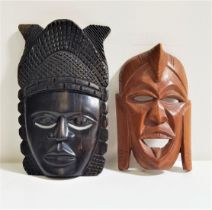 TWO AFRICAN CARVED MASKS one in ebony, 25.5cm high, the other in a hardwood, 20.5cm high (2)