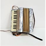 HOHNER MIGNON II ACCORDIAN with leather shoulder straps and a grey body