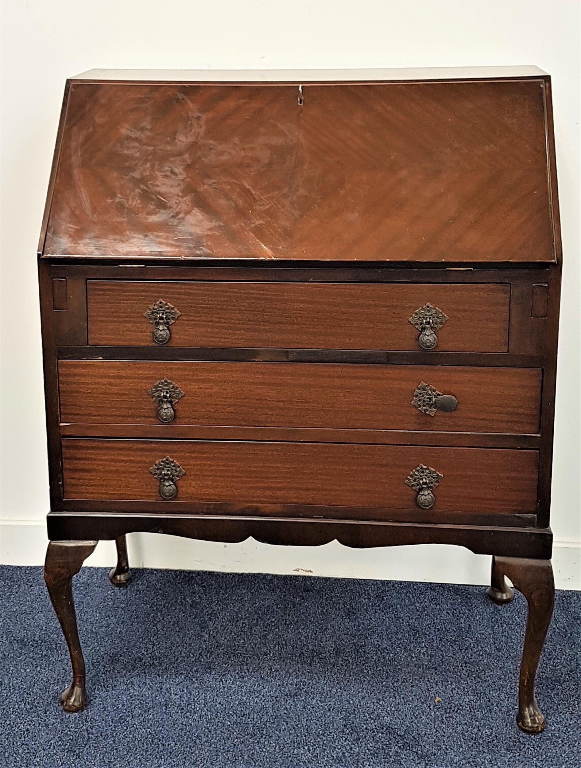 MAHOGANY BUREAU with a fall flap and fitted interior above three drawers, standing on cabriole