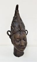 BENIN BRONZE FEMALE HEAD wearing a pinnacle hat with star decoration, her hair in plaits, 28cm high