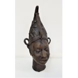 BENIN BRONZE FEMALE HEAD wearing a pinnacle hat with star decoration, her hair in plaits, 28cm high