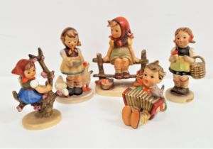 FIVE GOEBEL FIGURINES including a girl seated on a fence, 13cm high, girl feeding geese, 11.5cm