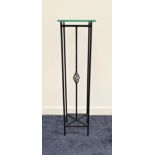 METAL TORCHERE with a square glass top on narrow metal supports with a central decorative metal