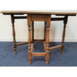 OAK GATELEG DINING TABLE with shaped drop flaps, standing on turned supports united by a