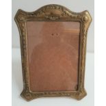 EARLY 20th CENTURY BRASS EMBOSSED PHOTOGRAPH FRAME decorated with swags of husks, with a fold out