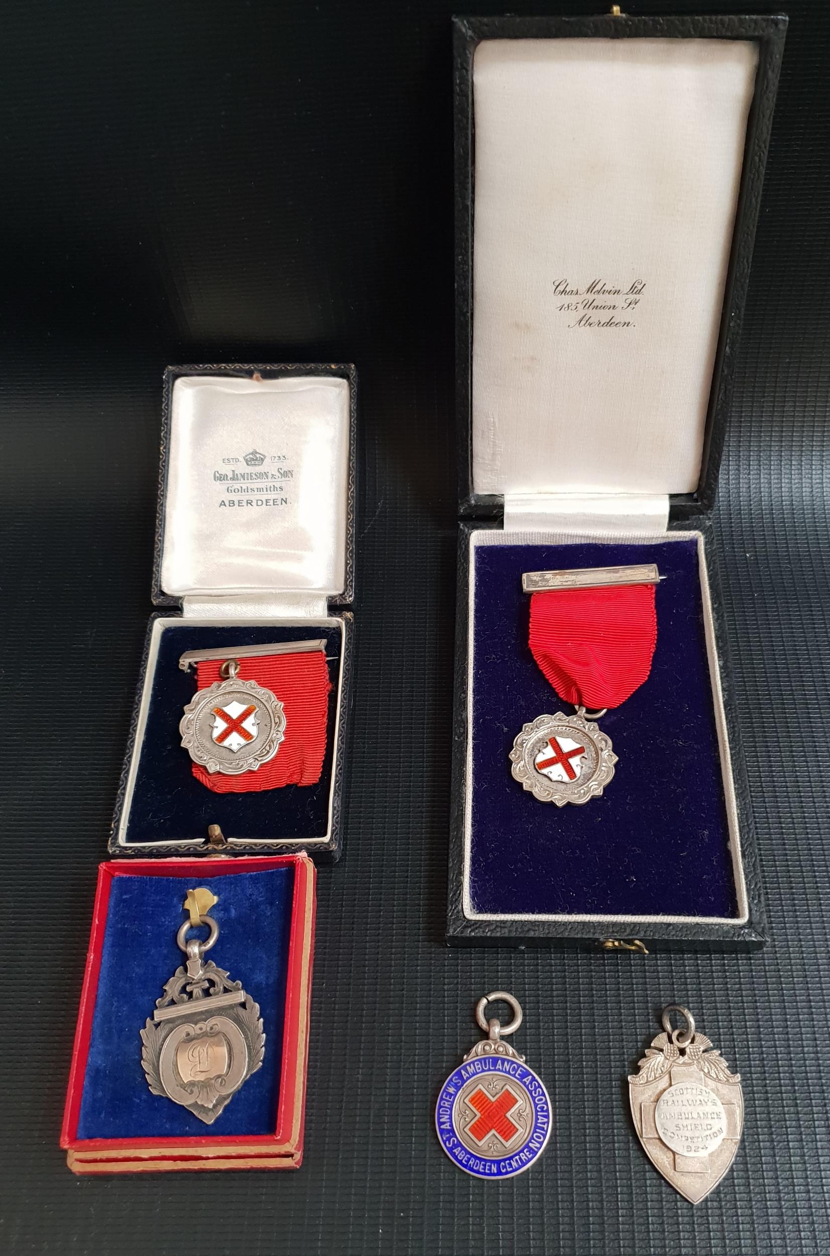 FIVE VARIOUS SILVER BADGES some with enamel decoration, including the Scottish Railway Ambulance